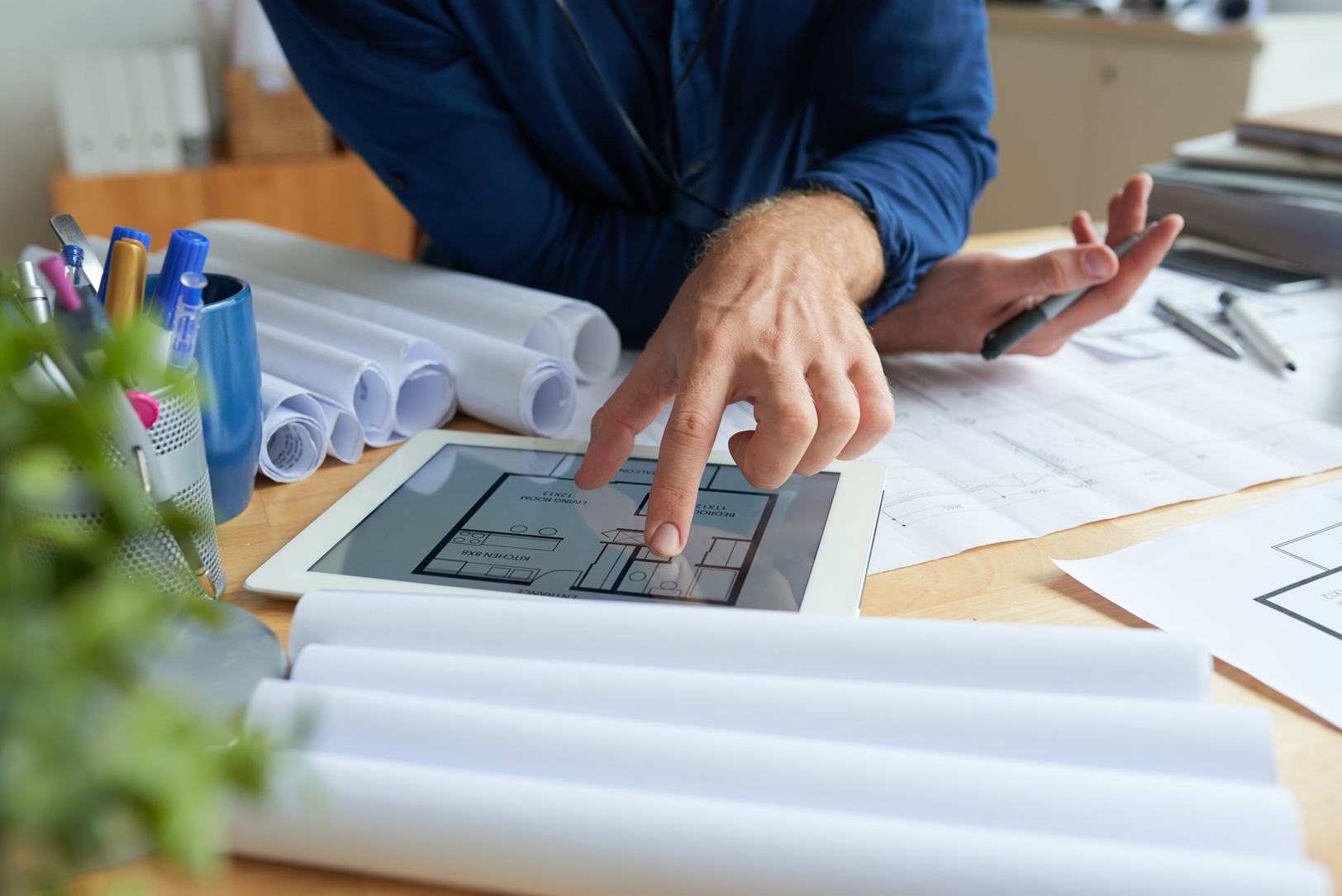 Technical drawings and project documentation being reviewed with a digital device